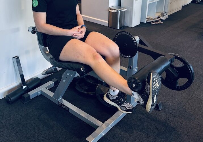 Niamh, a knee physio in Sydney, demonstrating knee extensions, one of the best physio exercises for knee pain