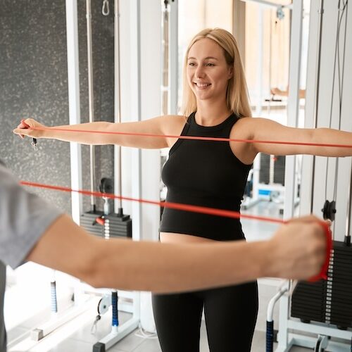 Pregnant woman with a women's health physio doing band exercises
