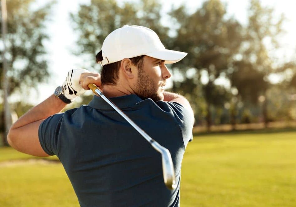 young-man-shooting-golf-ball Young golfer improving his golf swing with a golf physio